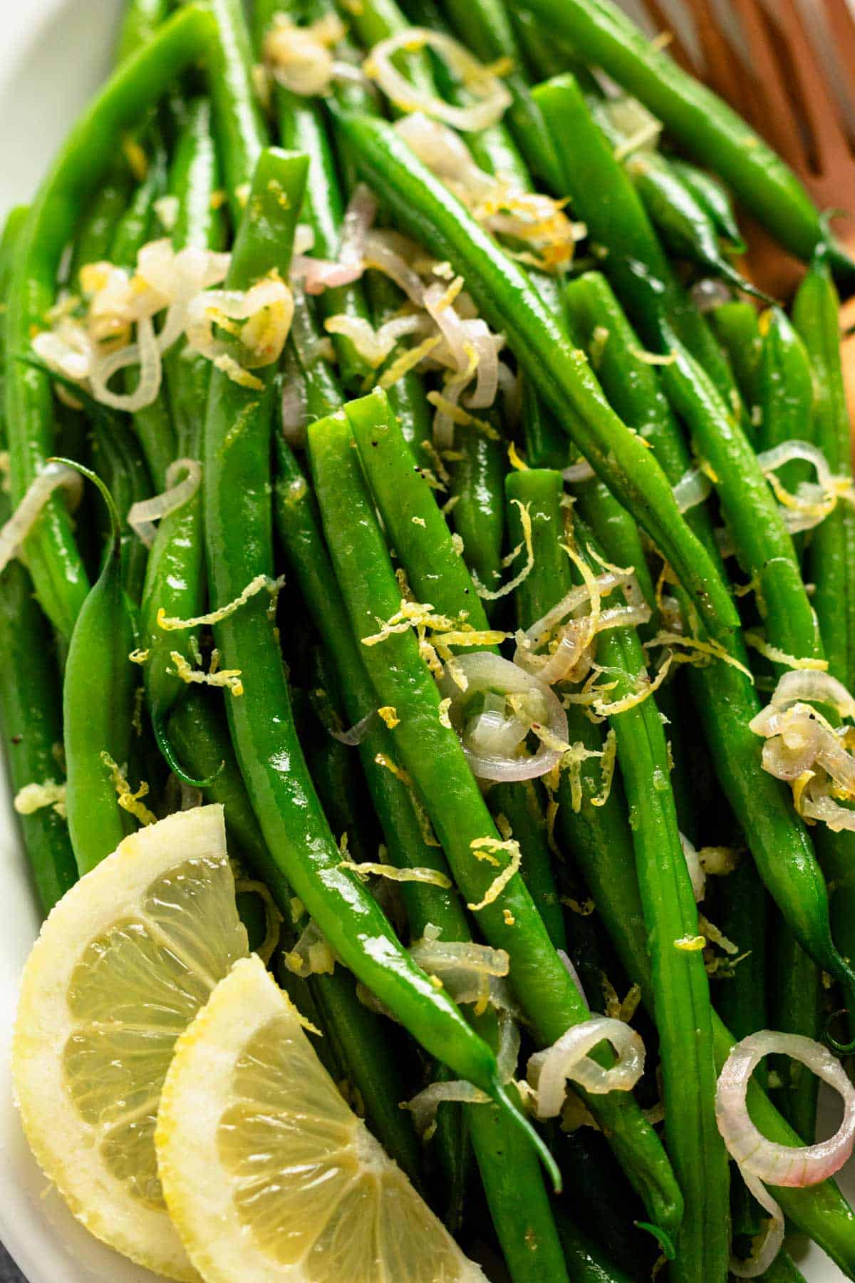 ready to be served garnished green beans with lemon slices.