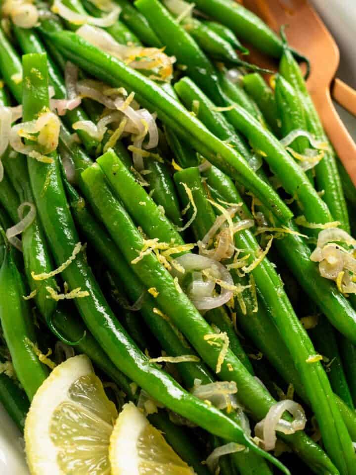 ready to be served garnished green beans with lemon slices.