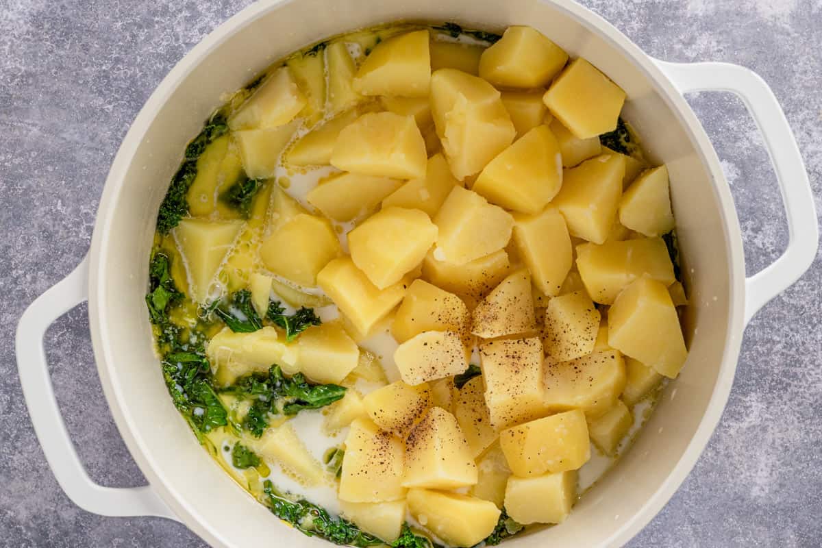 potato chunks cooking in pot with kale and leeks