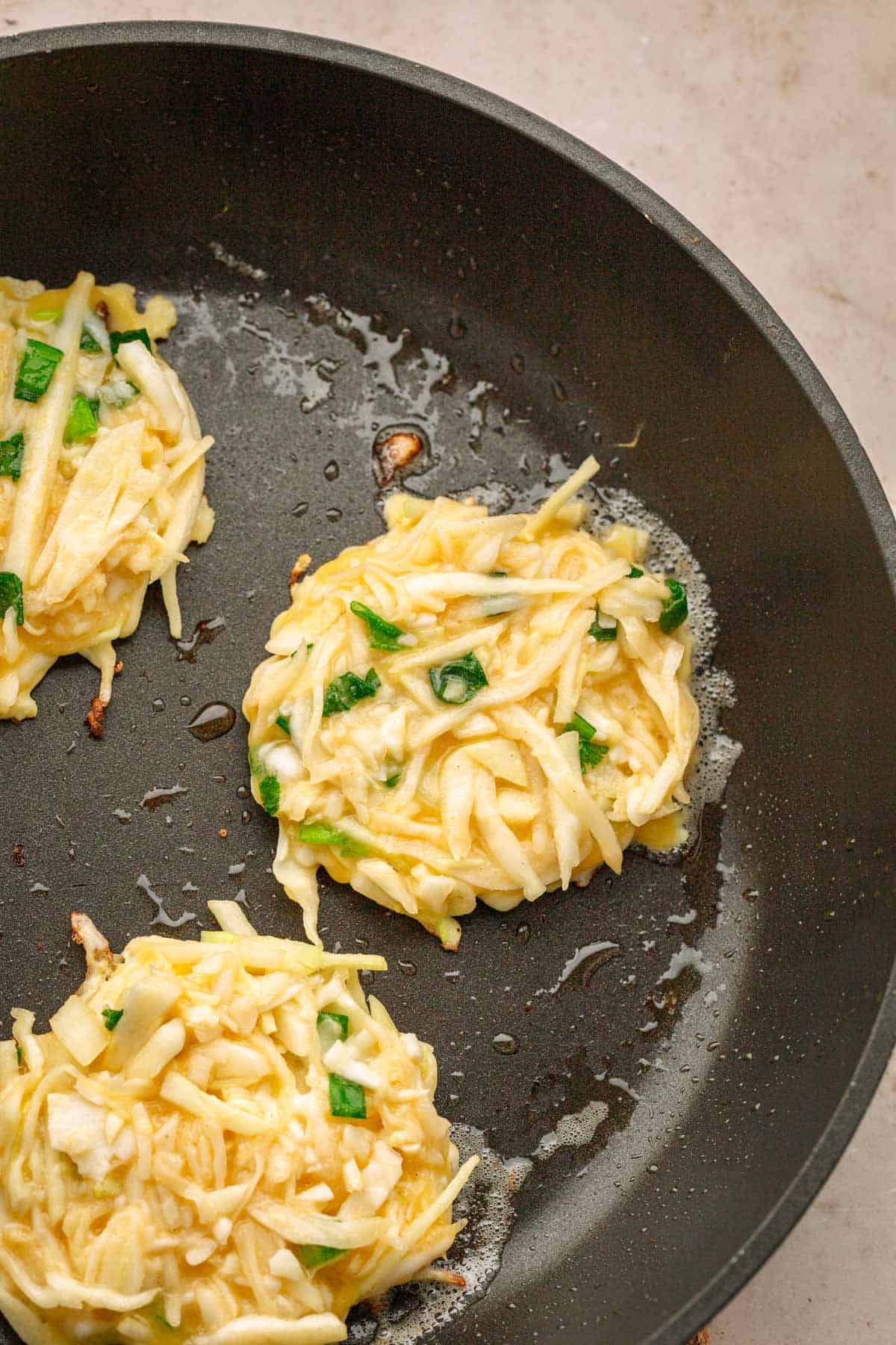 Frying cabbage pancakes in skillet.