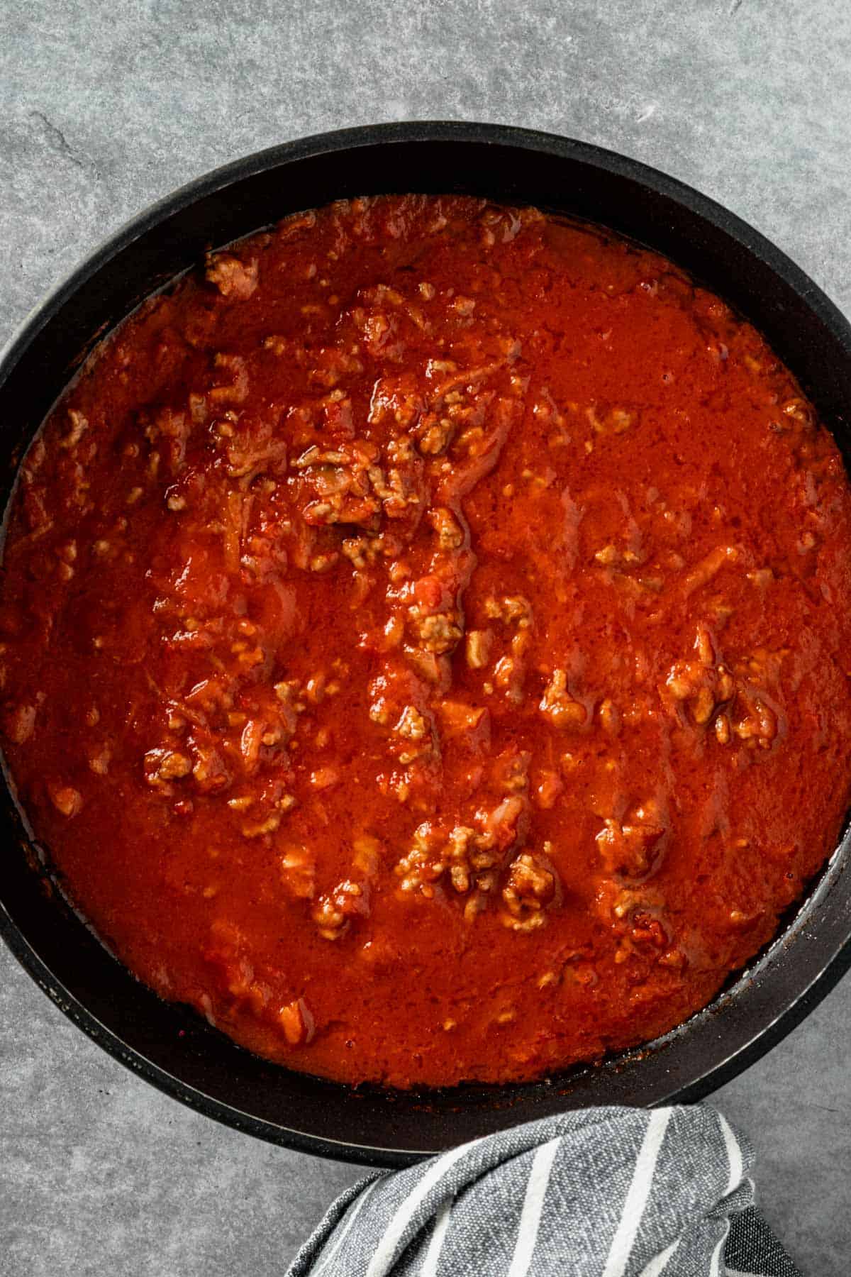 tomatoes added to ground beef mixture in skillet