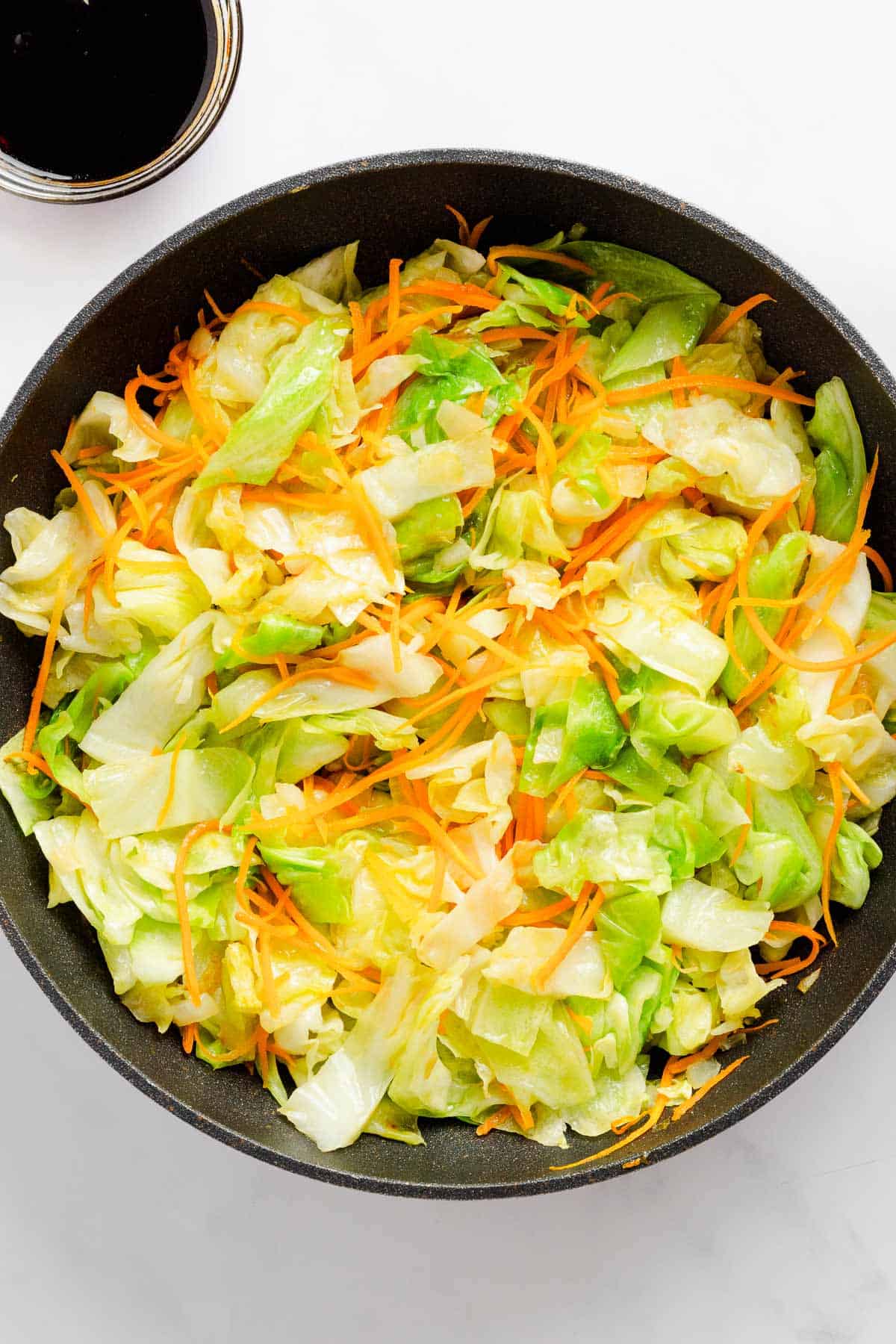 cabbage in skillet with carrots.