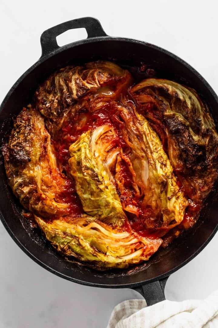 caramelized cabbage with tomato in skillet.