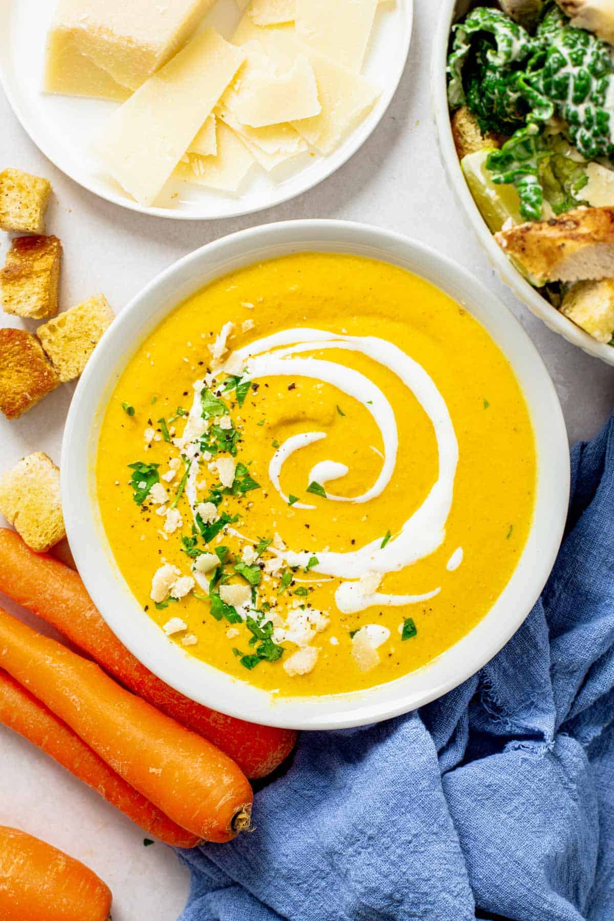 carrot ginger turmeric soup with cream in a serving bowl