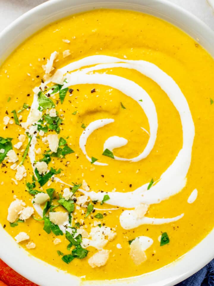 carrot ginger turmeric soup with cream in a bowl