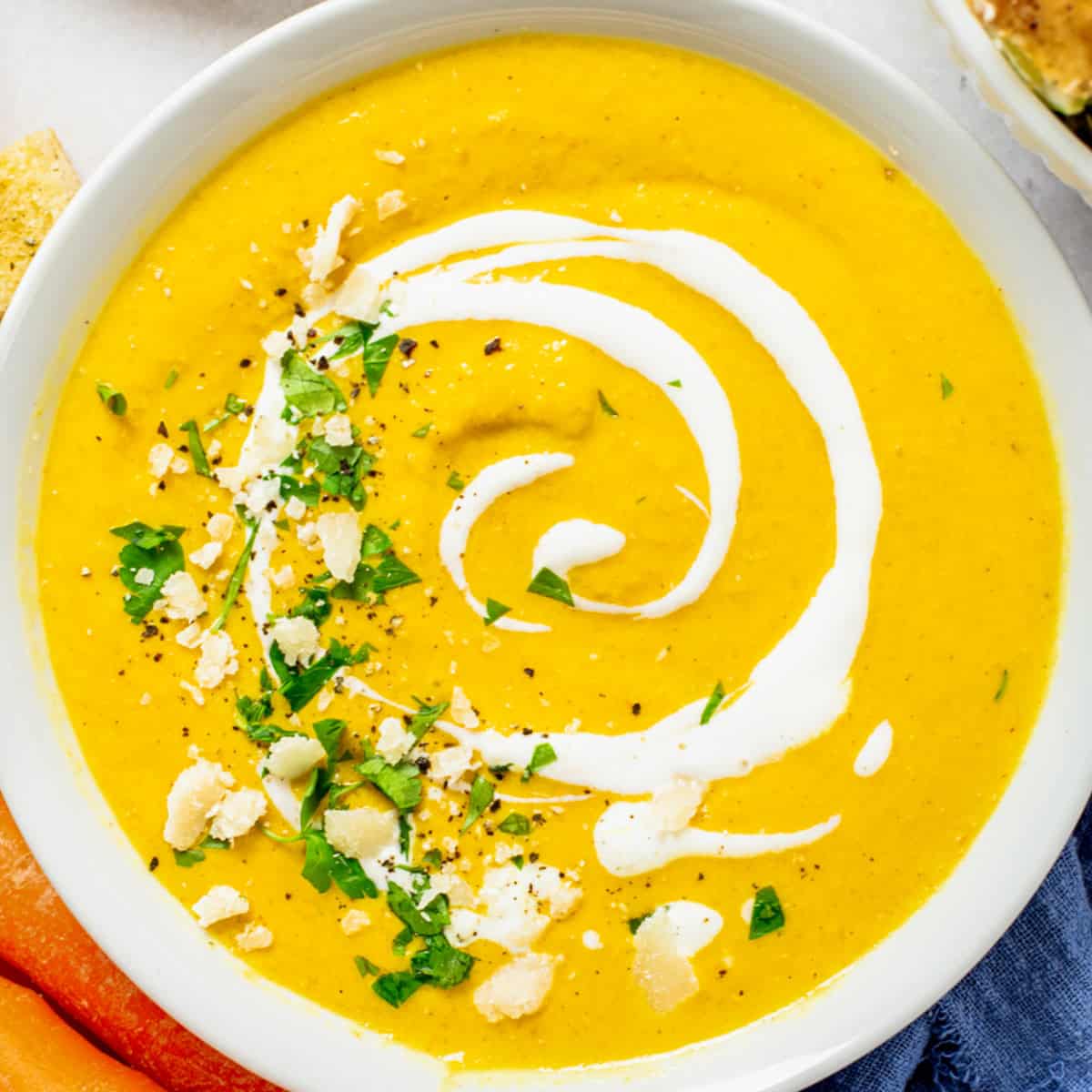 carrot ginger turmeric soup with cream in a bowl