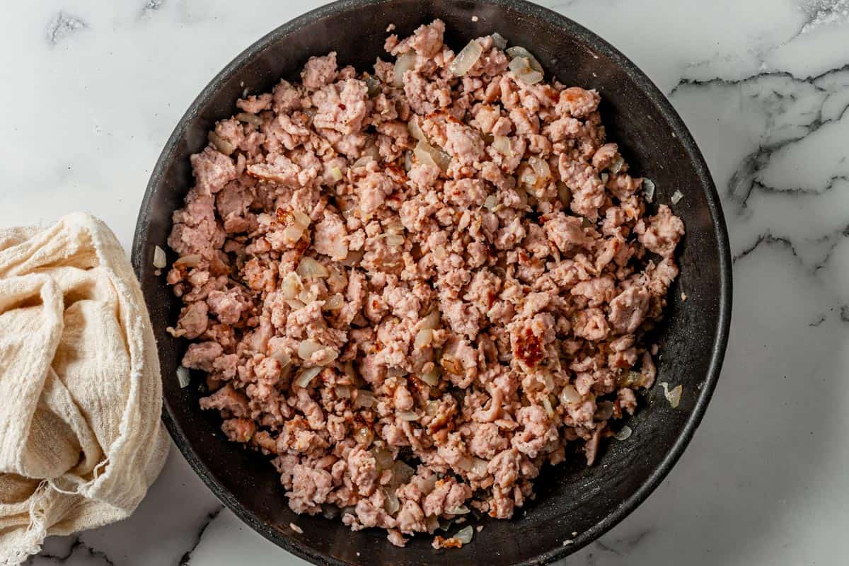 picture of ground chicken cooking in black skillet