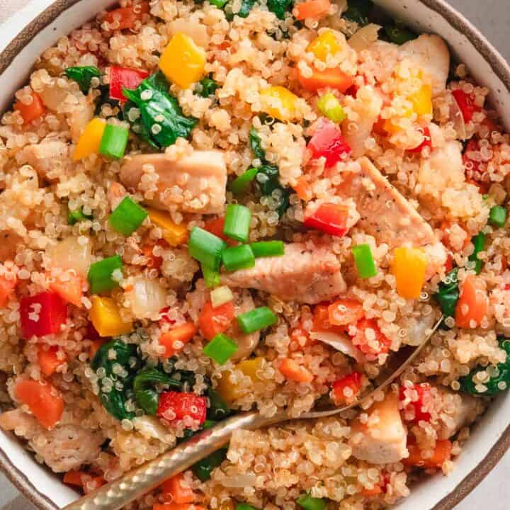 Thai chicken quinoa bowl with vegetables and green onions.