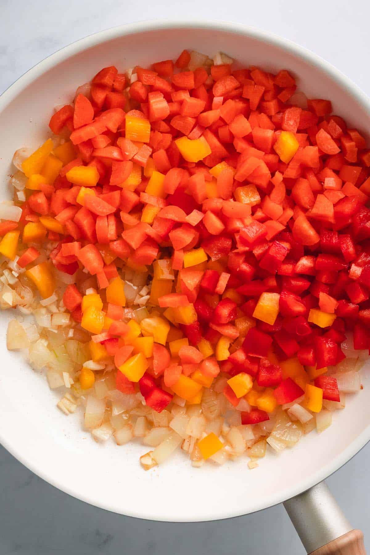 Finely diced red and yellow bell peppers prepared for stir fry.