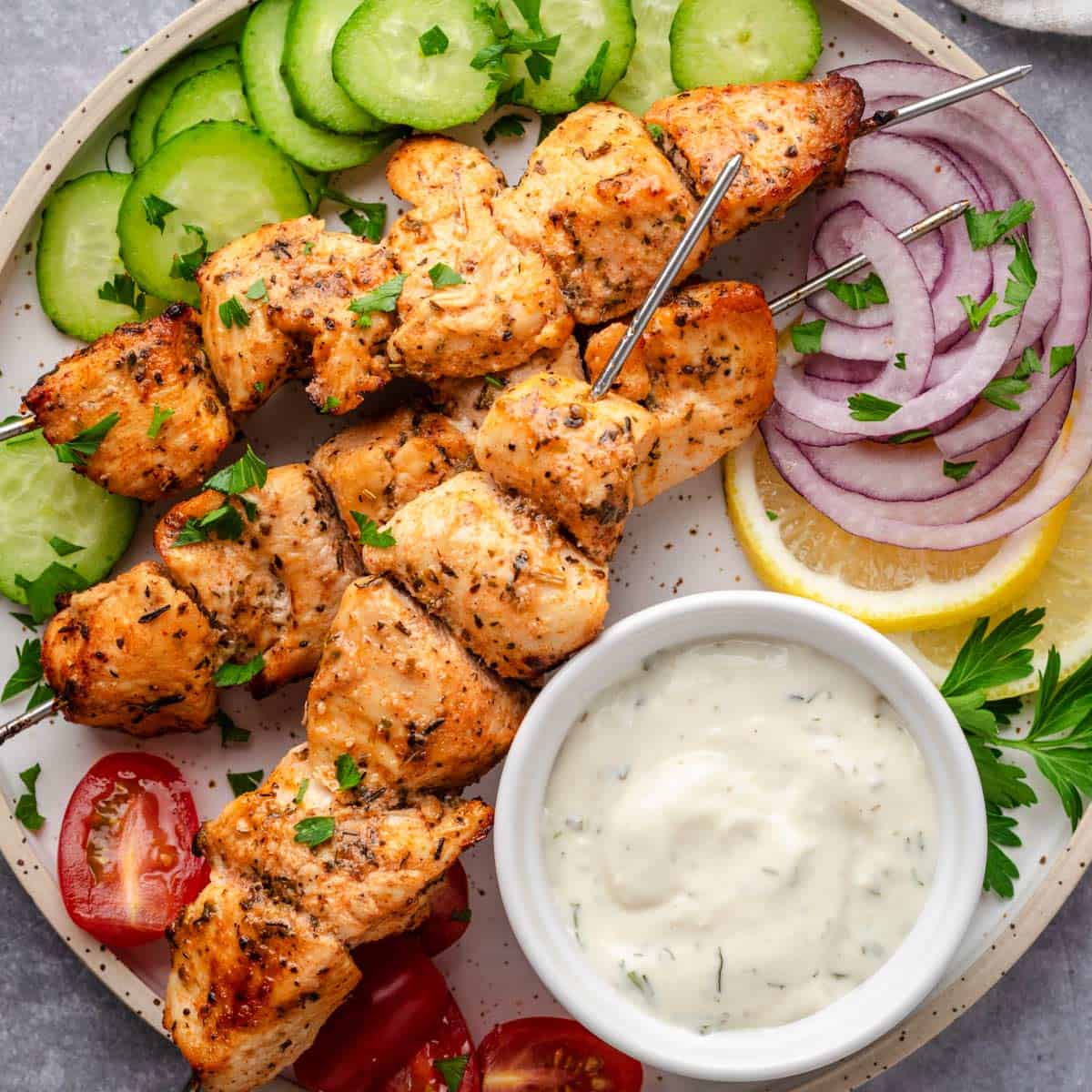 Chicken souvlaki skewers with fixings.