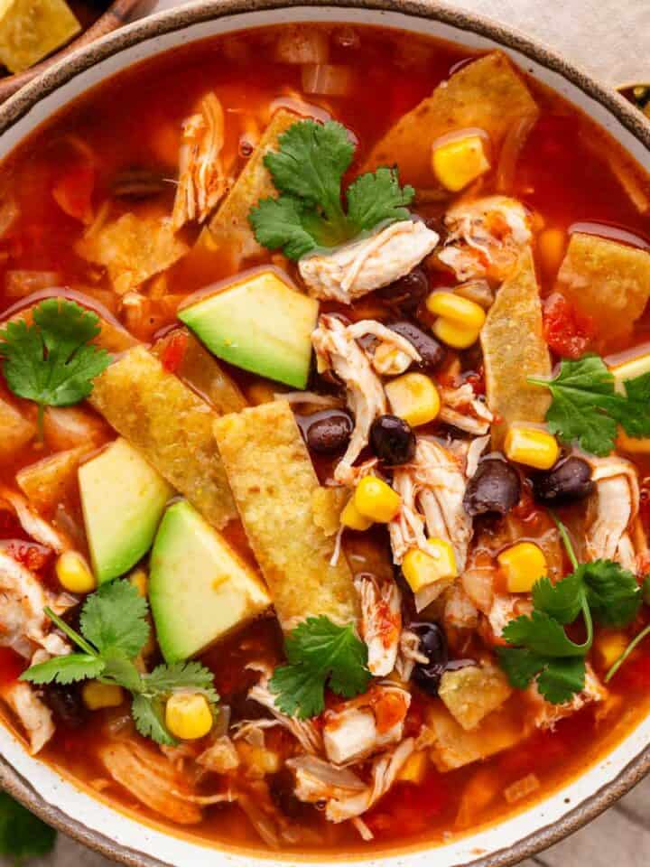 chicken tortilla soup with toppings in a bowl.