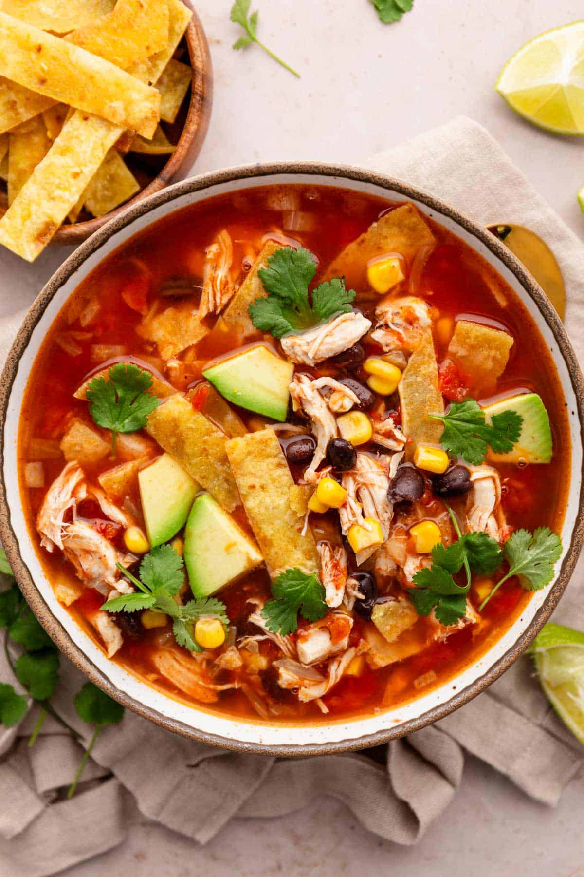 chicken tortilla soup with toppings in a bowl.
