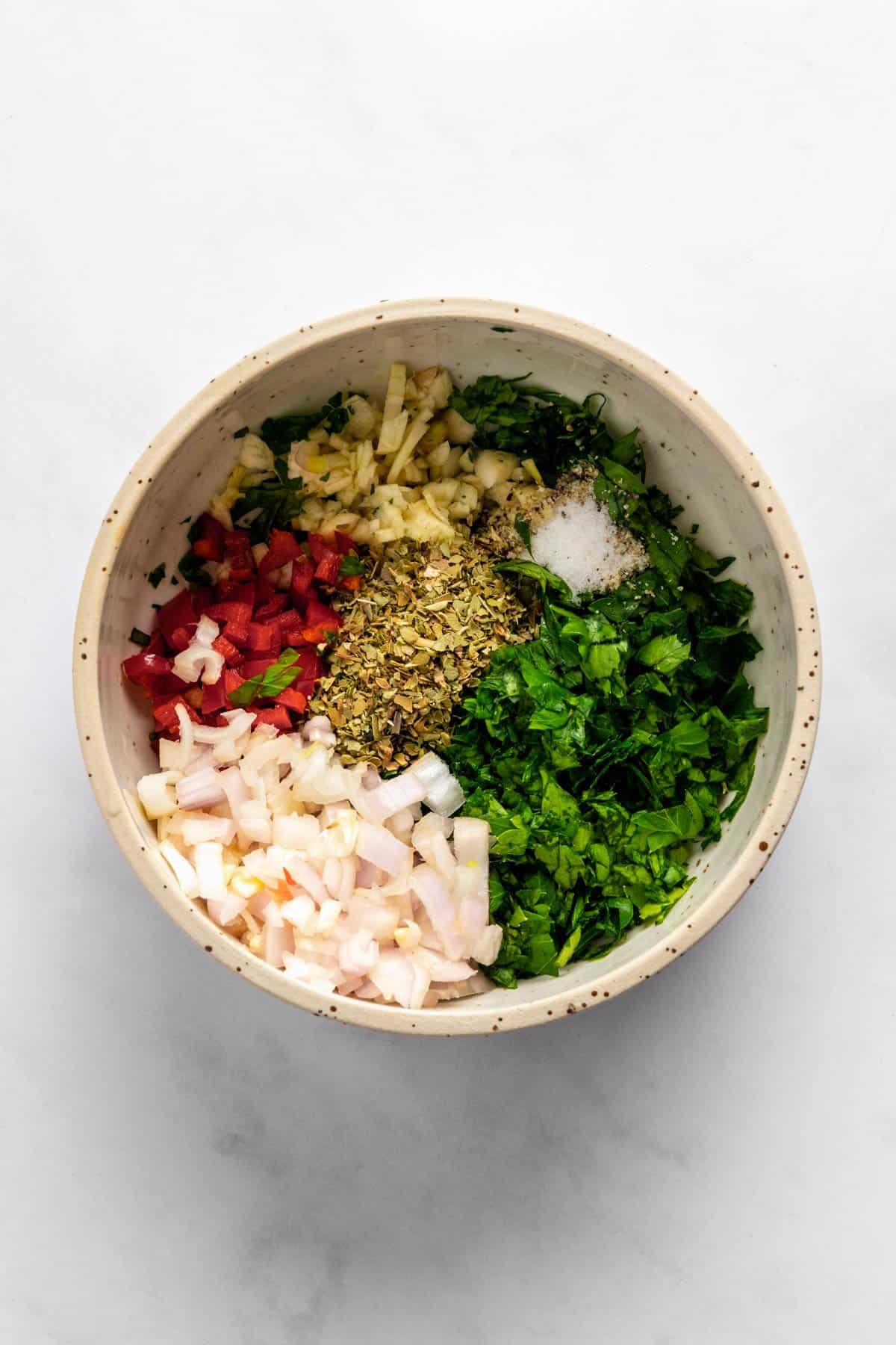 all ingredients for chimichurri sauce in a bowl before mixing