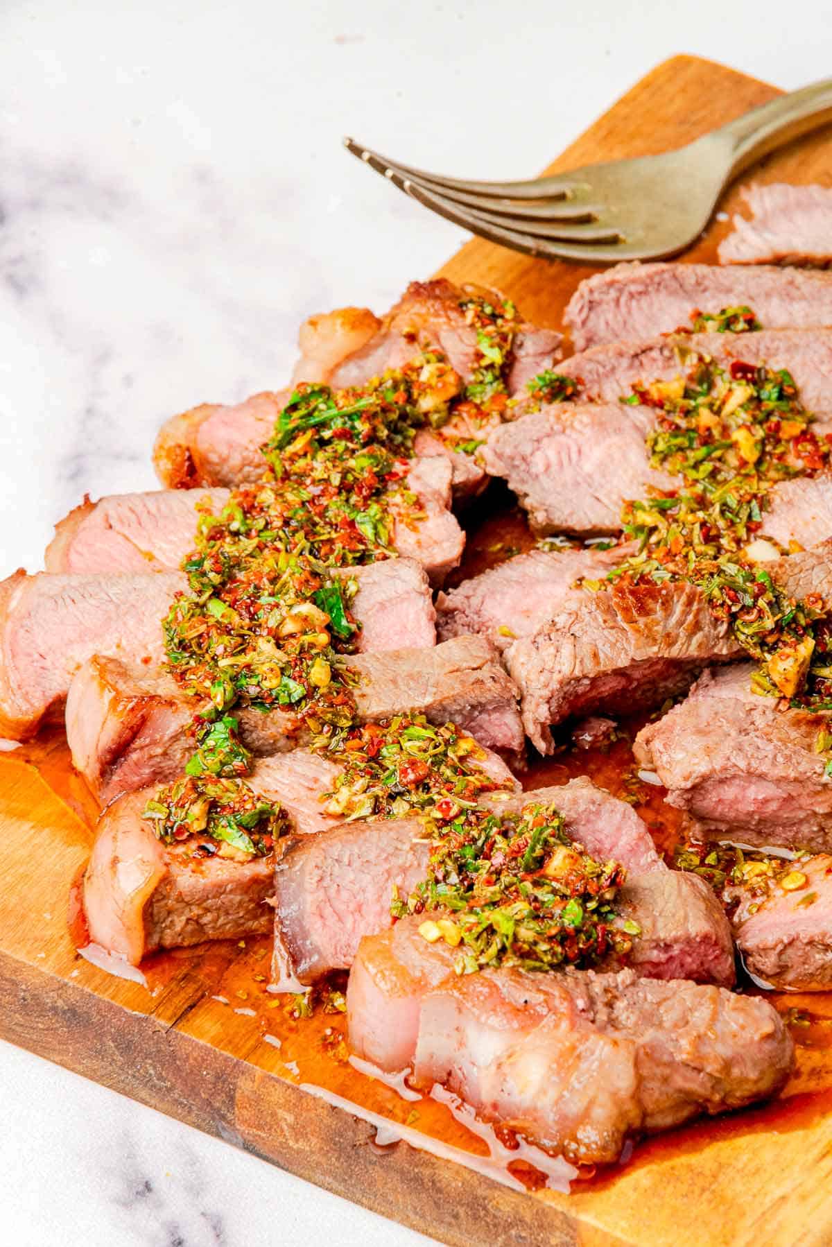 Steak slices topped with Chimichurri sauce.