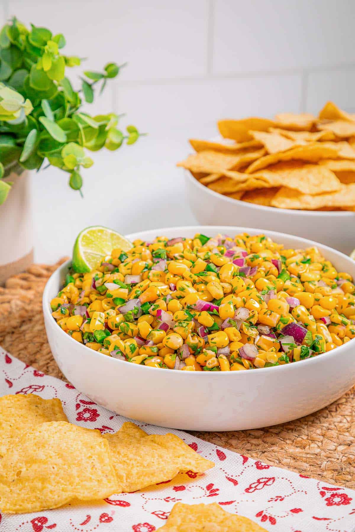 Corn salsa inspired by Chipotle served as a fresh dip with tortilla chips, overhead view.