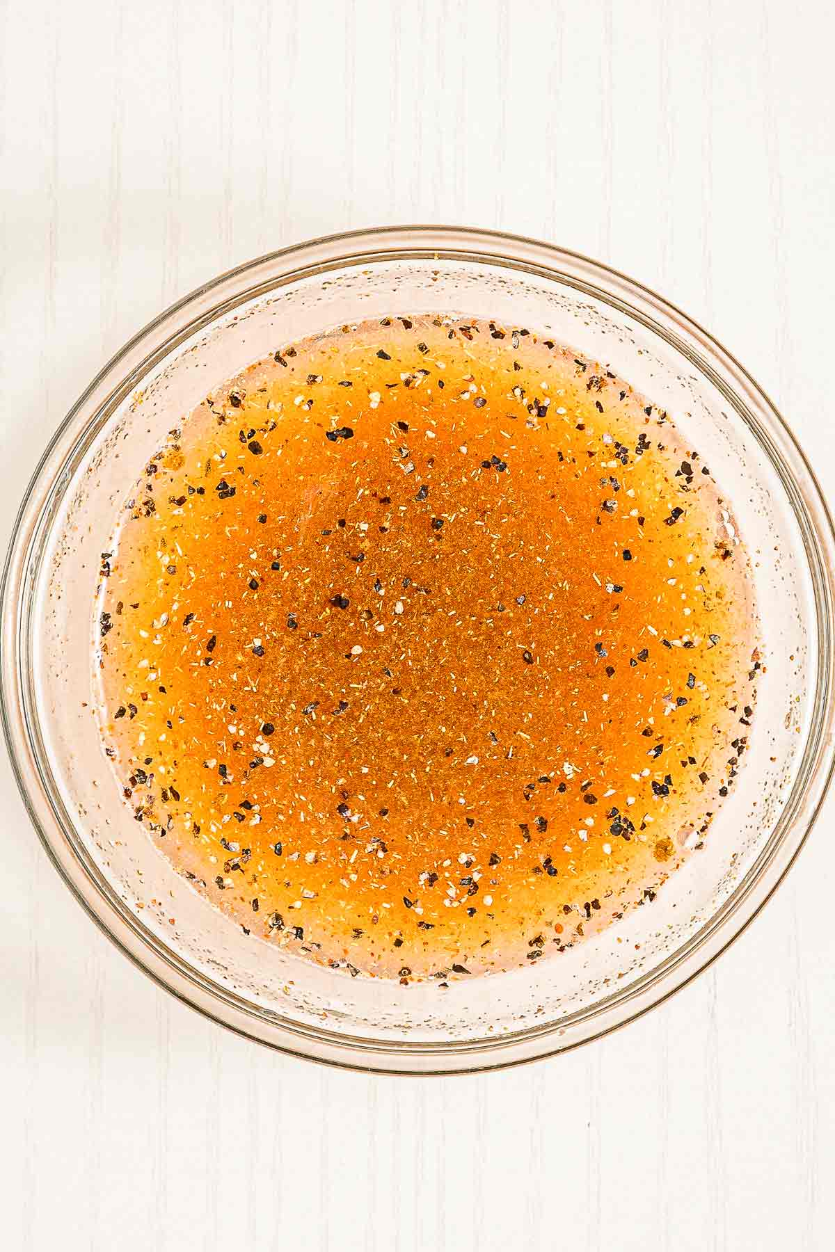 Lime dressing for chipotle corn salsa made with spices, lime juice, and black pepper in a small bowl.