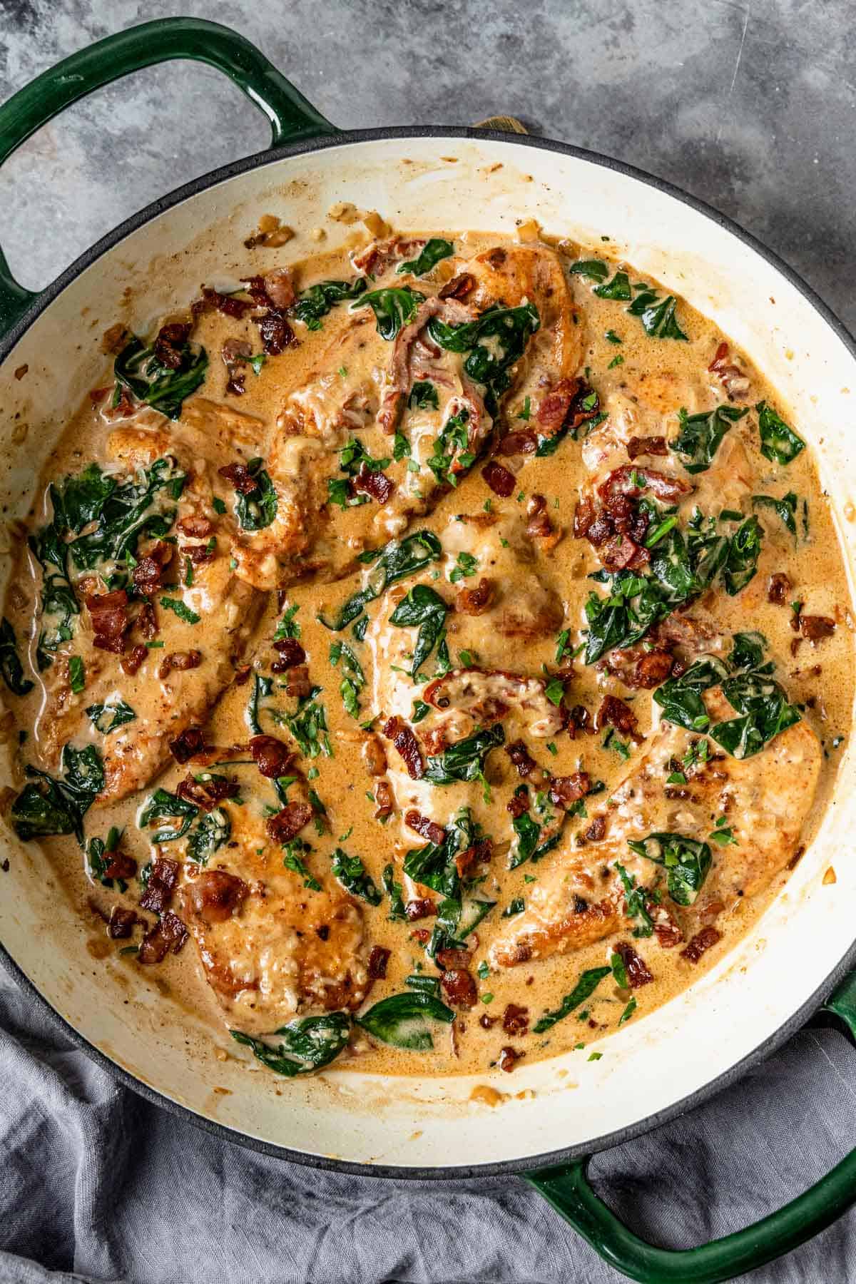 Chicken breasts in an irresistible creamy sun dried tomato sauce filled with spinach, delicious smoked paprika, parmesan, and topped up with salty crispy bacon is definitely a winner of a chicken dinner! - The Yummy Bowl