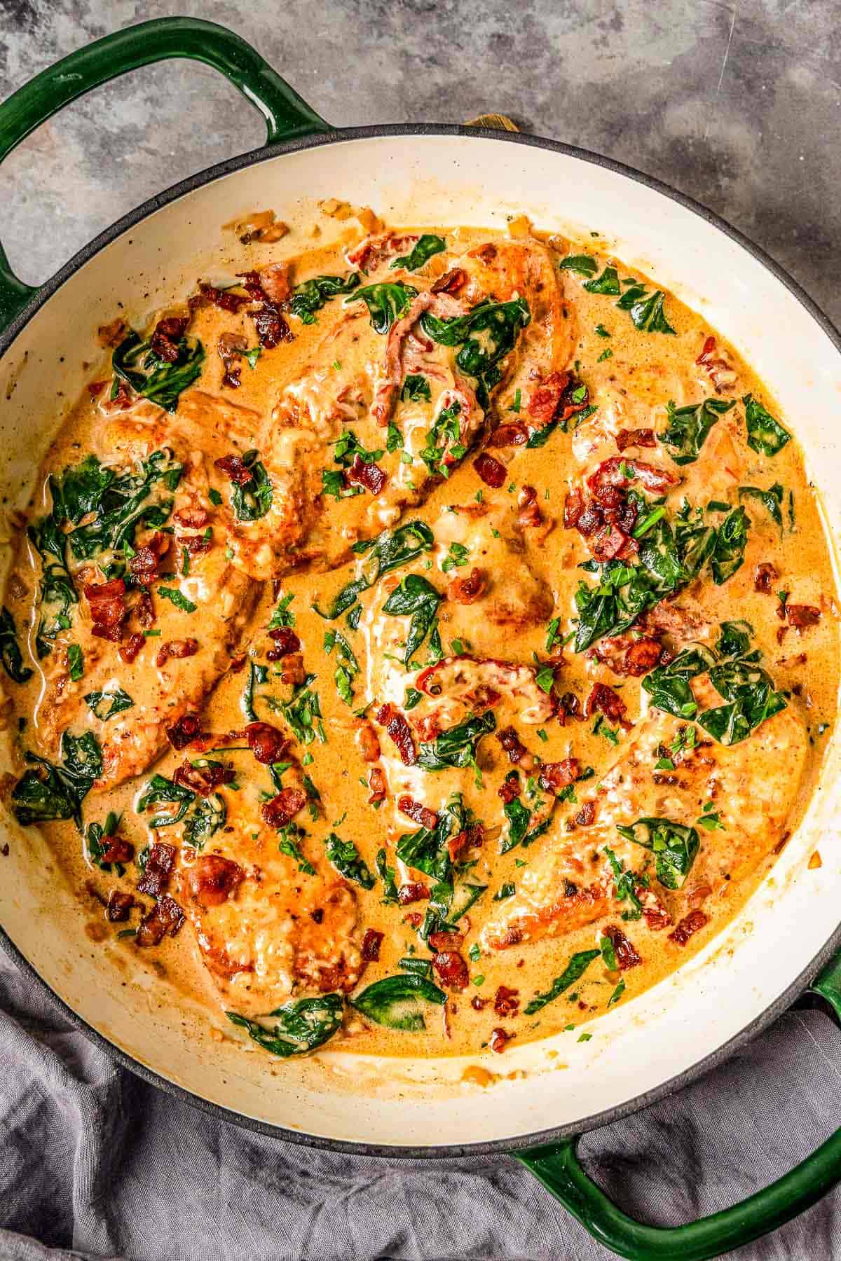 Chicken breasts in an irresistible creamy sun dried tomato sauce filled with spinach, delicious smoked paprika, parmesan, and topped up with salty crispy bacon is definitely a winner of a chicken dinner! - The Yummy Bowl