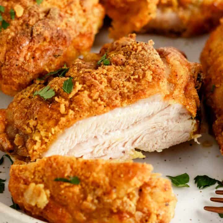 crispy skin sliced chicken thighs on a plate.