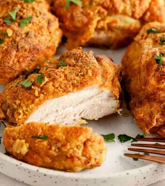 crispy skin sliced chicken thighs on a plate.