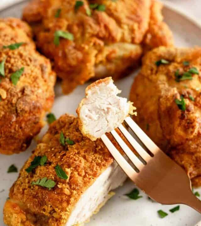 crispy skin sliced chicken thighs on a plate.