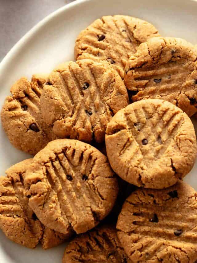 a bunch of peanut butter cookies with chocolate chips on a plate.