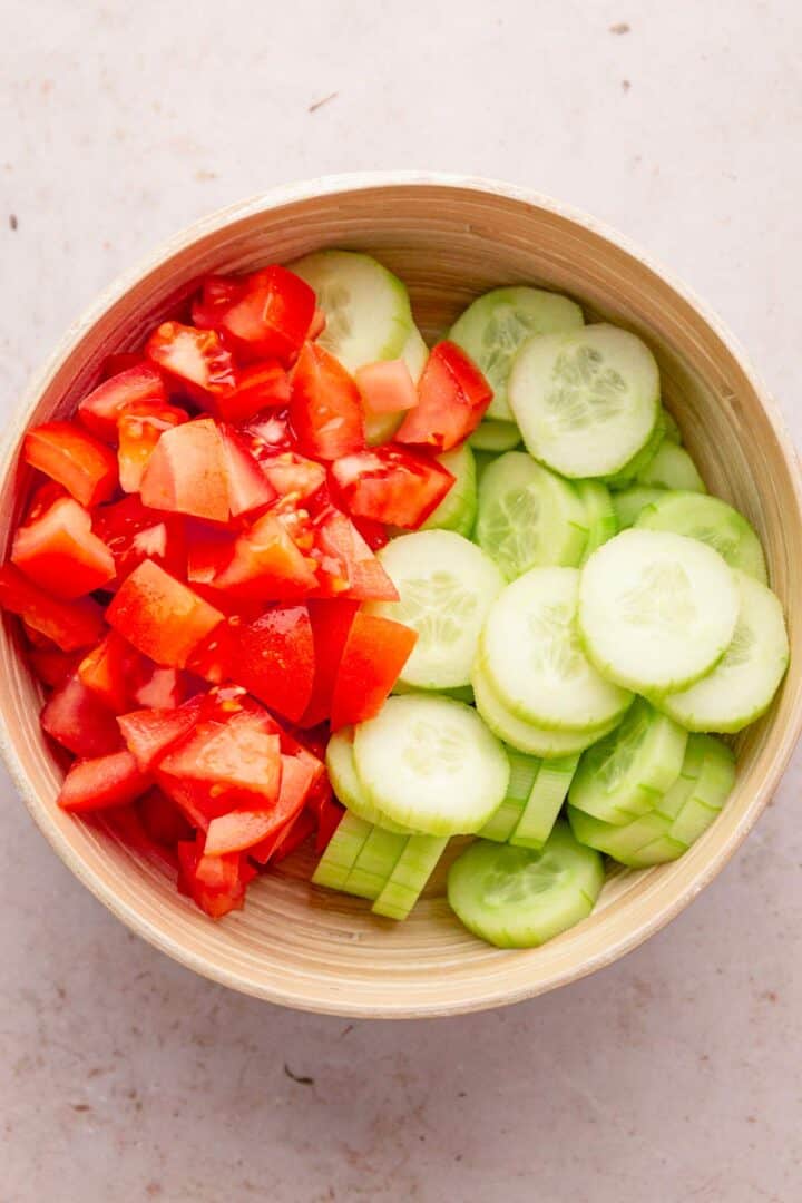 sliced cucumbers and tomato in a bowl.