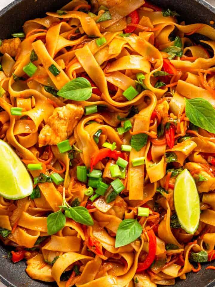 rice noodles with vegetables and lime wedges.