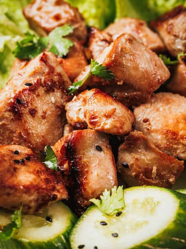 Cooked lemongrass chicken bites with golden edges and fresh herbs.