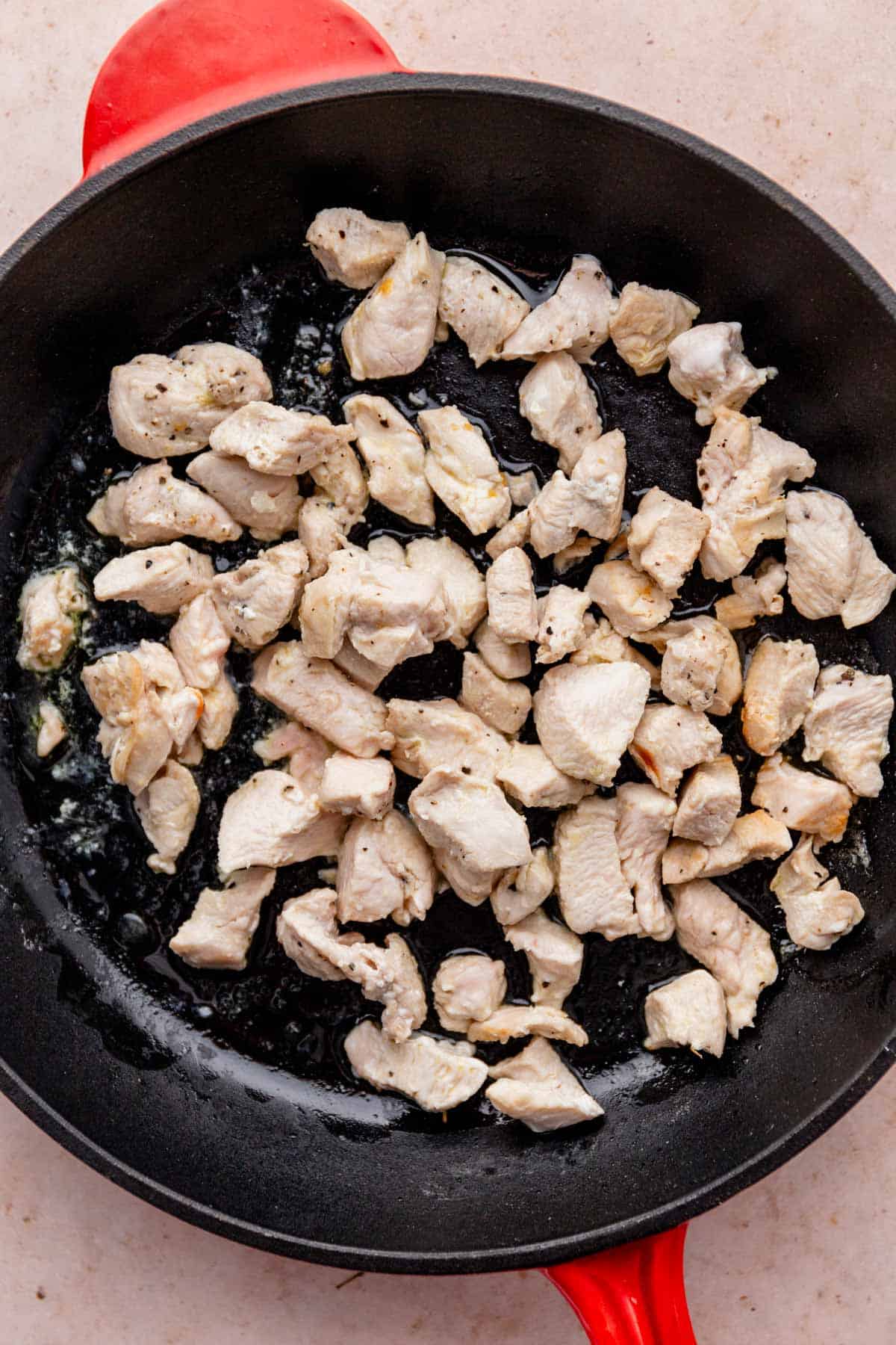 cooking chicken pieces in skillet.