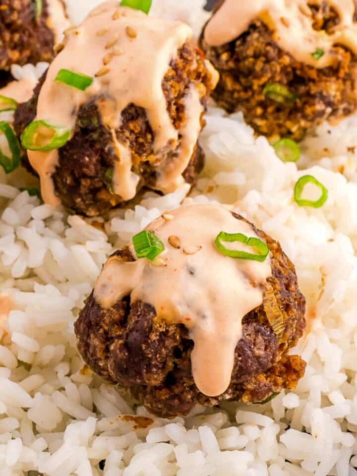 firecracker meatballs with rice and spicy sriracha sauce.
