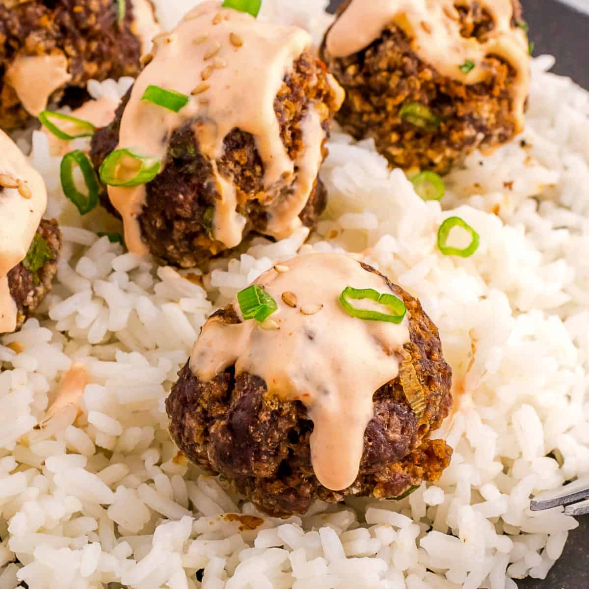 firecracker meatballs with rice and spicy sriracha sauce.