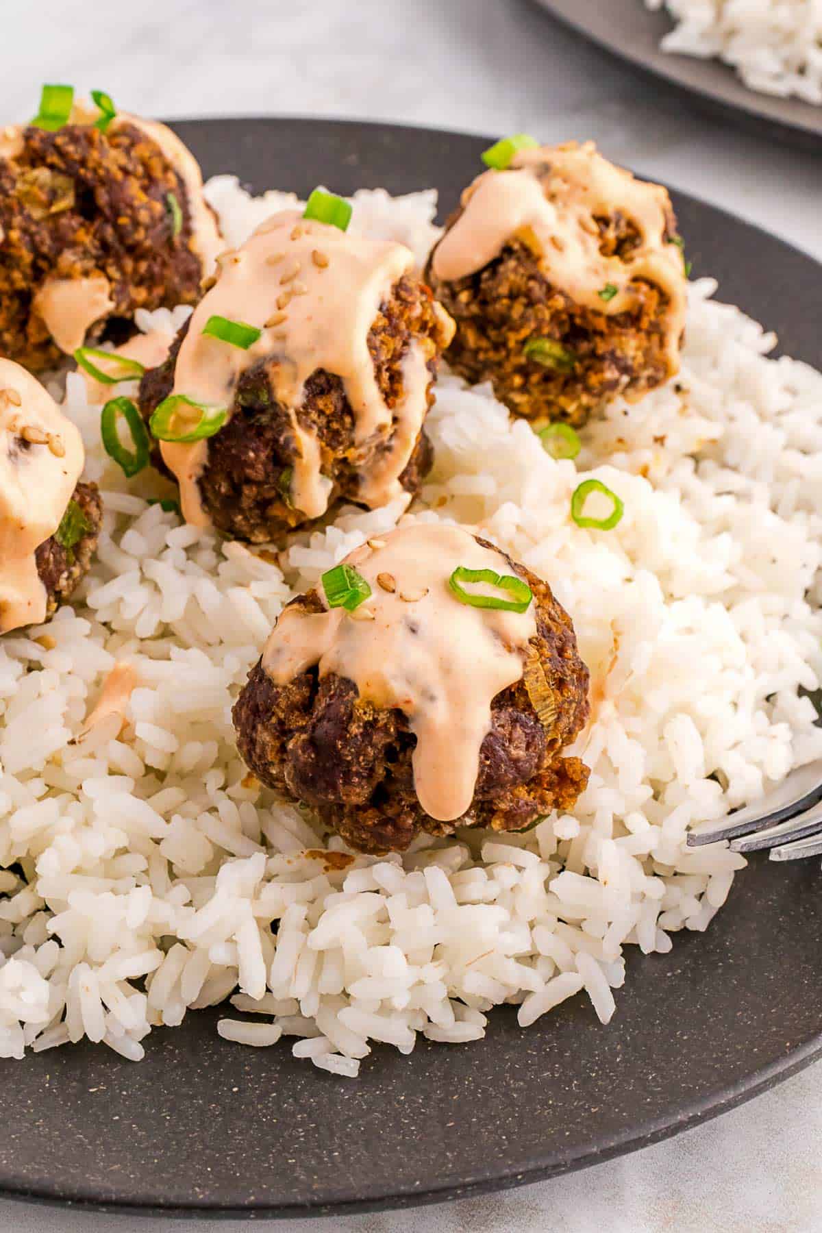 firecracker meatballs with rice and spicy sriracha sauce.