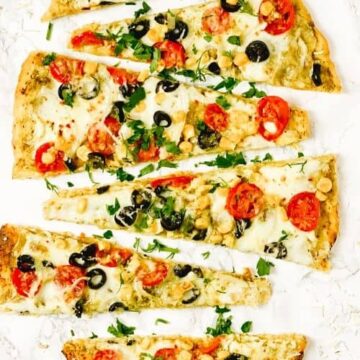 This Easy Basil Pesto Flatbread is very easy to make and has all the best ingredients - cherry tomatoes, onion, corn, olives, garlic oil, spinach leaves, mozzarella. This flavorful flatbread with roasted tomatoes will be the highlight of your dinner and will be gone from table in seconds - The Yummy Bowl