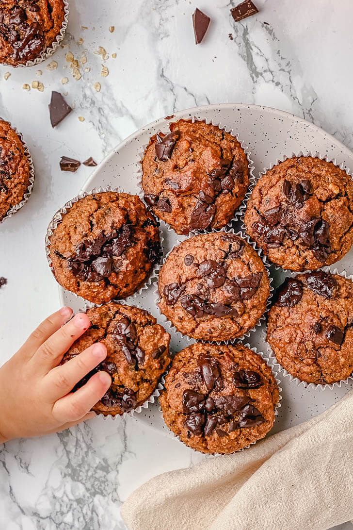 An easy recipe for pumpkin muffins. These oat flour pumpkin muffins are gluten-free, filled with chocolate, nuts and have no refined sugar. They’re deliciously soft and moist, perfect to enjoy with a warm cup of coffee at breakfast.  #glutenfreepumpkinmuffins #glutenfreepumpkinmuffinseasy #glutenfreepumpkinmuffinsalmondflour #glutenfreepumpkinmuffinsoatmeal #pumpkinchocolatechipmuffins