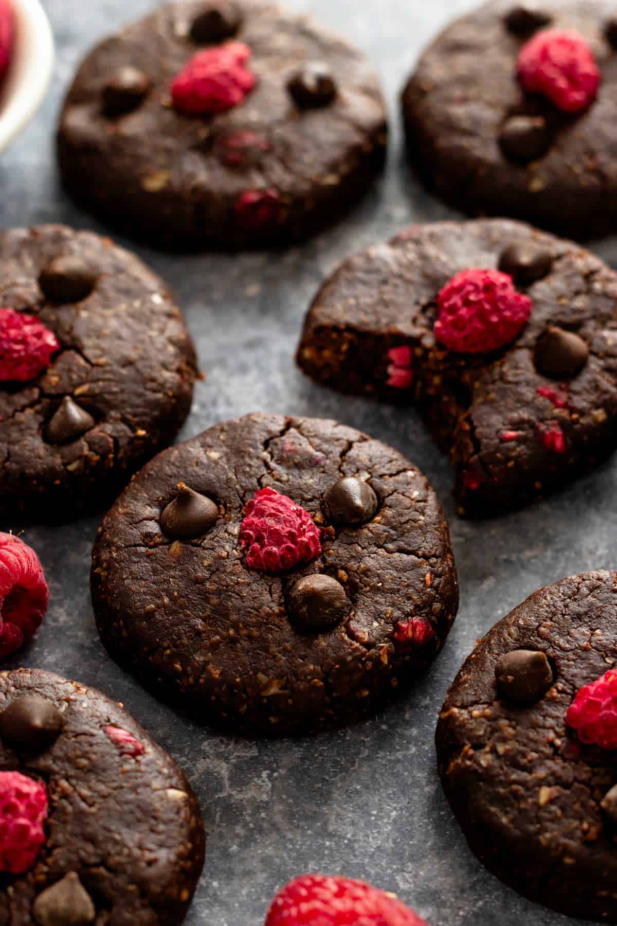 no bake dark chocolate cookies with raspberries with a dark background.