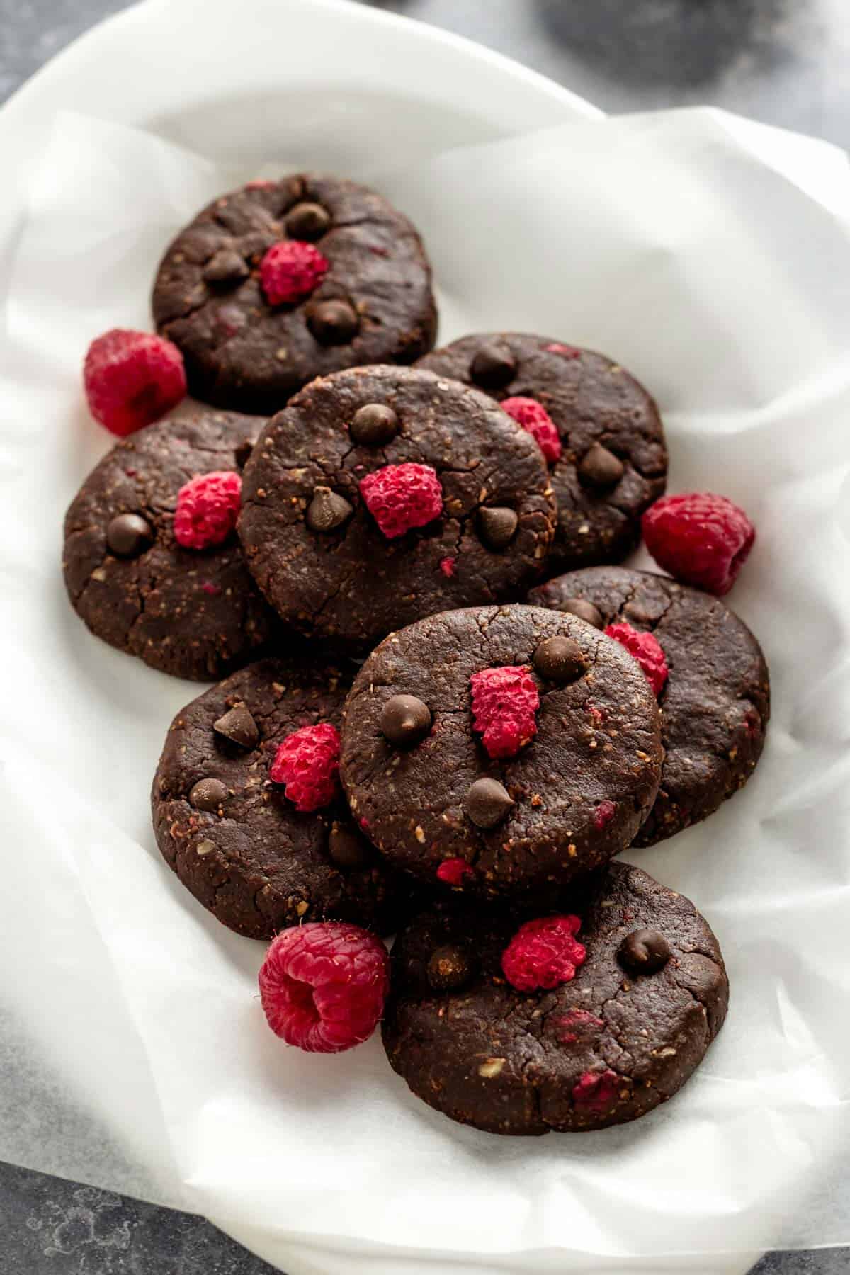 no bake dark chocolate cookies with raspberries in an oval plate.