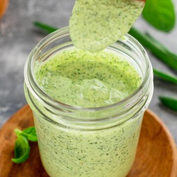 creamy green dip in a jar with spoon drizzle
