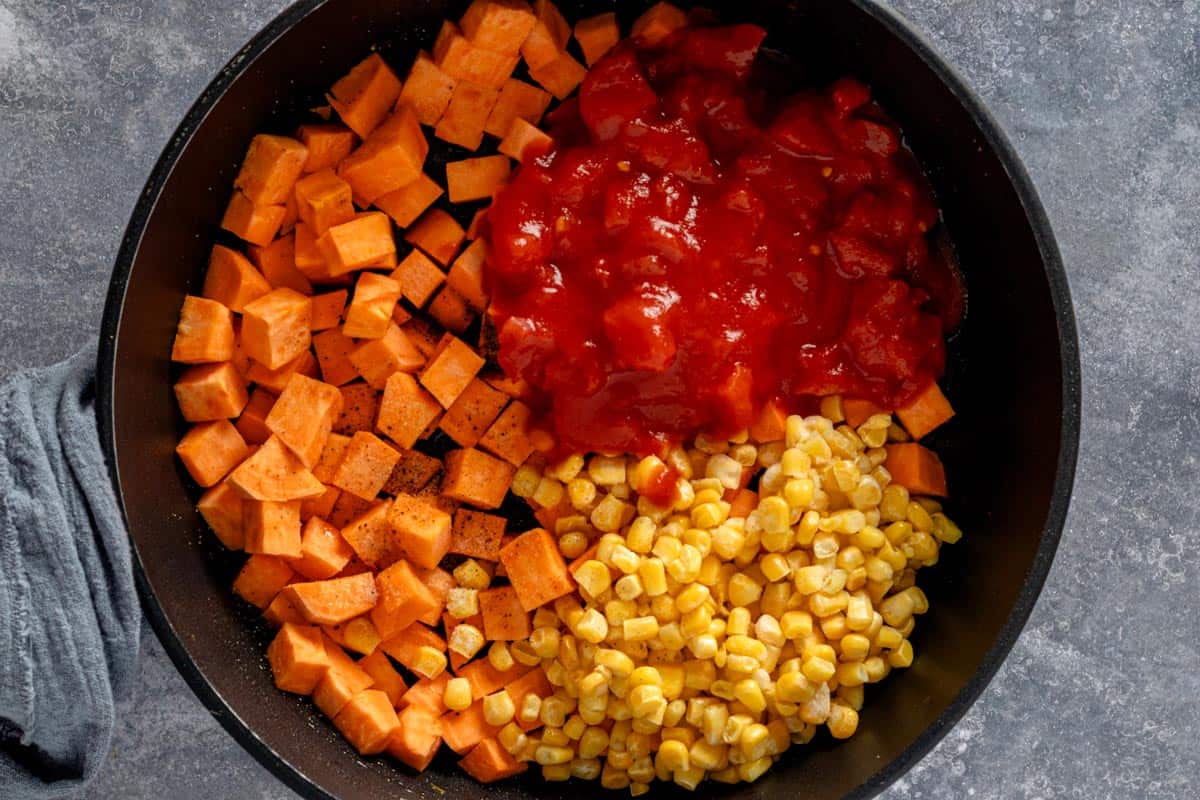 cooking sweet potatoes with diced tomatoes and corn.