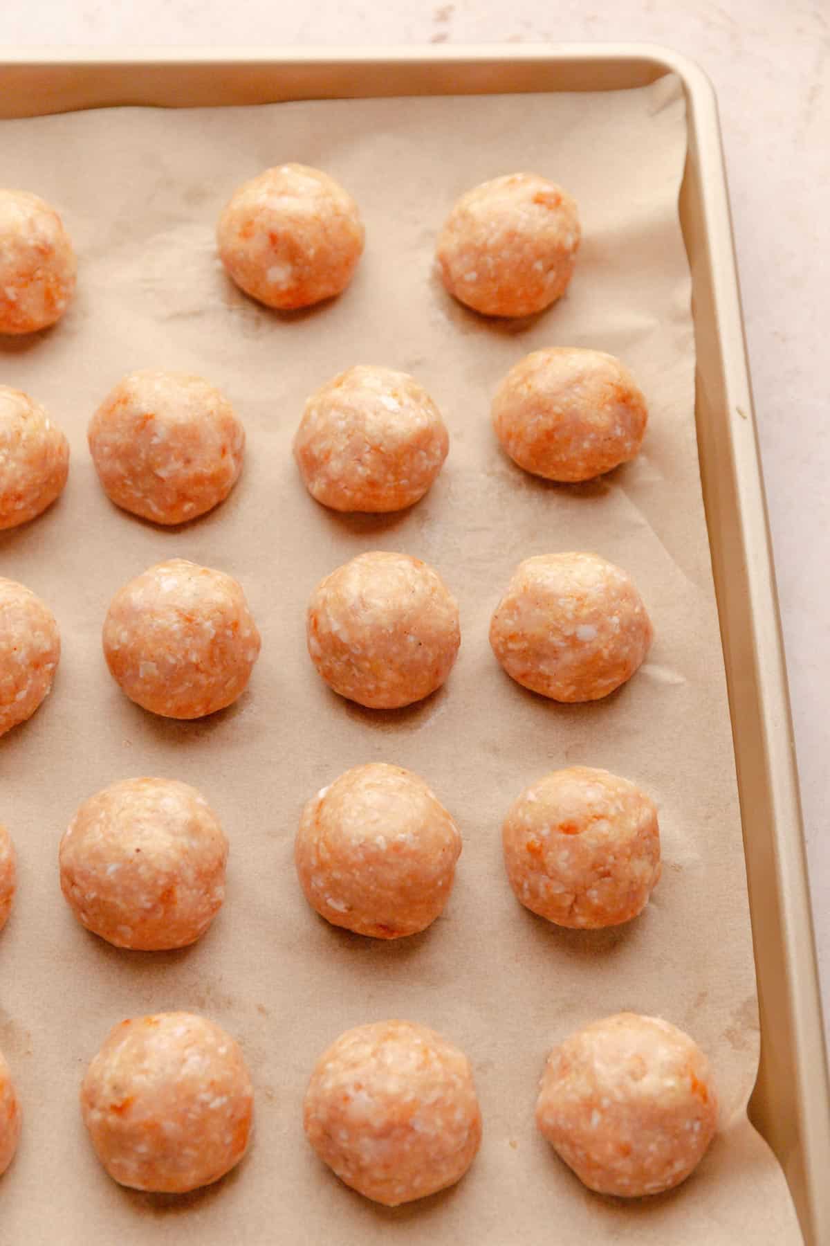 Small ground chicken meatballs before baking.