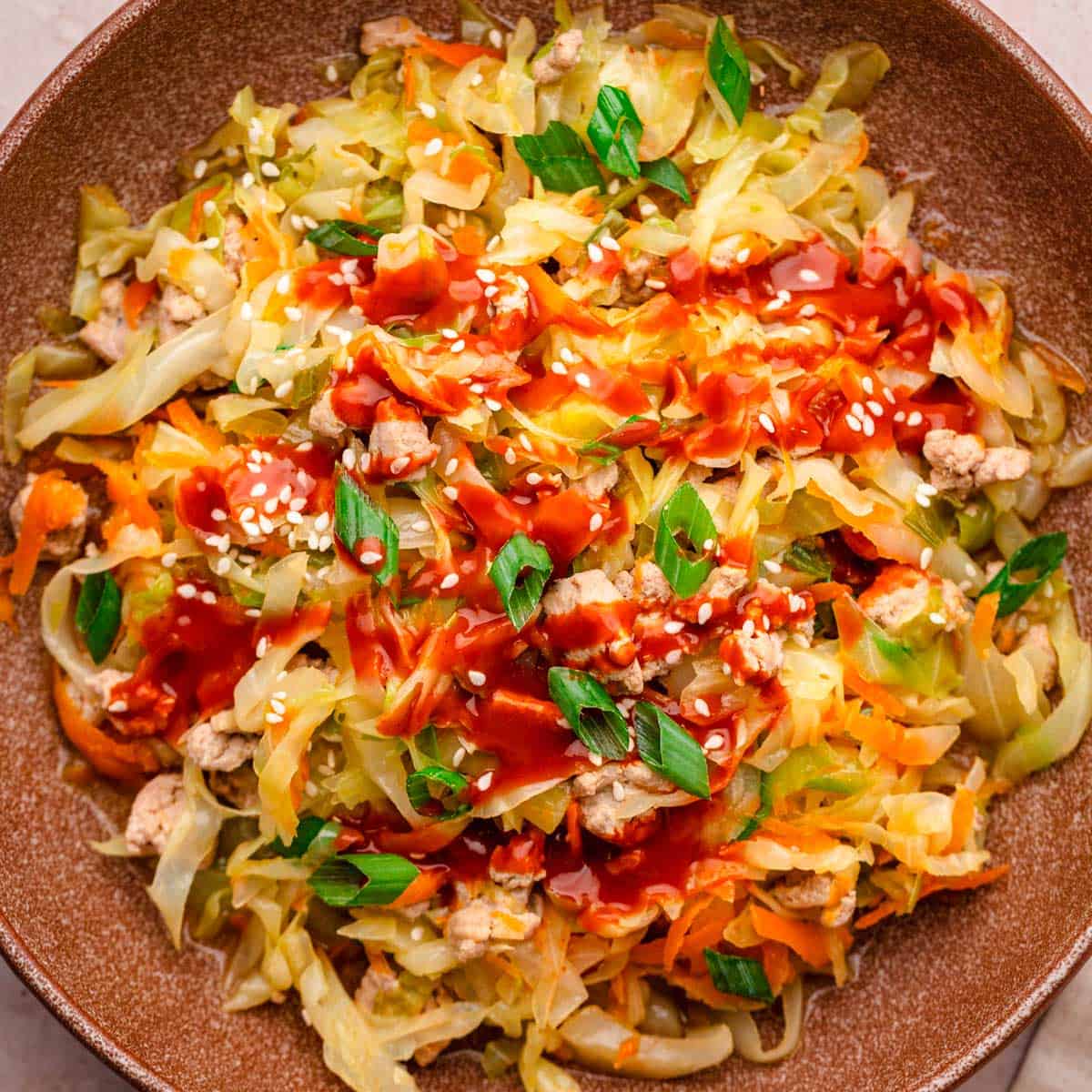 Ground turkey cabbage stir fry with sriracha and sesame seeds.