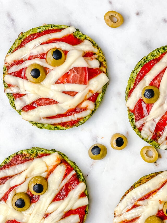 Halloween Mummy Pizzas - is the perfect Halloween party or dinner idea. Make these mummies with your kids for an easy and super flavorful Halloween themed meal. These mini pizzas are also gluten-free! The Yummy Bowl #savouryhalloweenfood #halloweenfoodrecipes #halloweenmummypizza #mummypizza #creepyhalloweenfoodideas #traditionalhalloweenfood #halloweentreats 