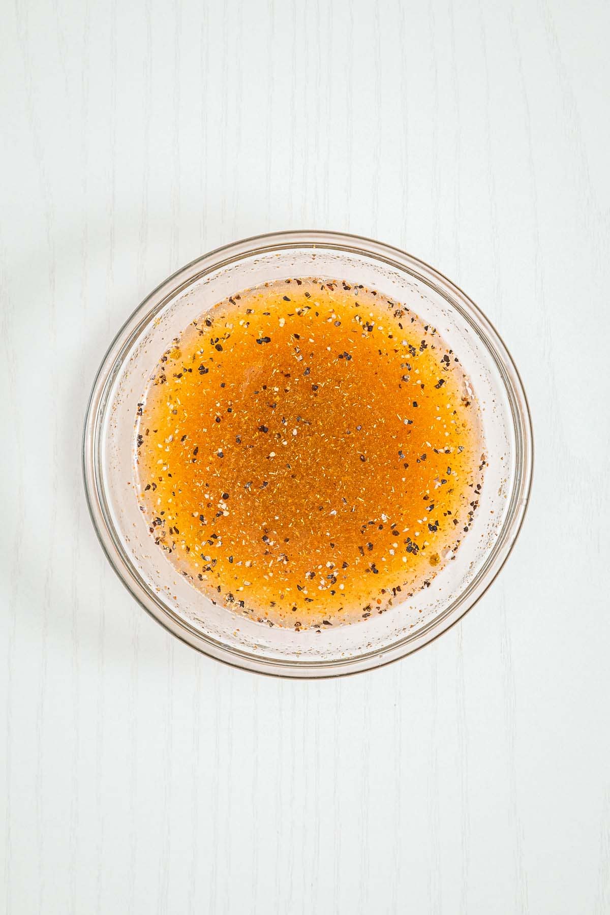 Lime dressing for chipotle corn salsa made with spices, lime juice, and black pepper in a small bowl.