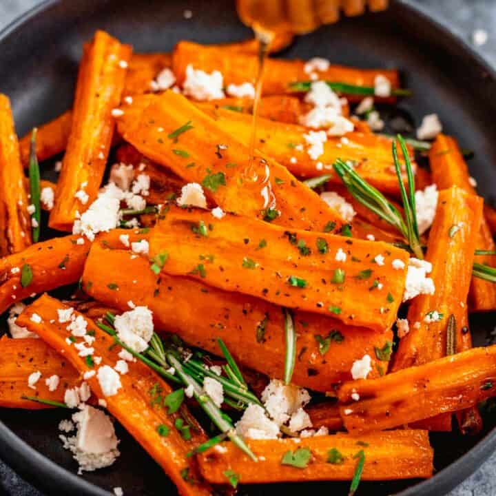 Honey Glazed Carrots In Air Fryer With Feta and Rosemary in a black bowl