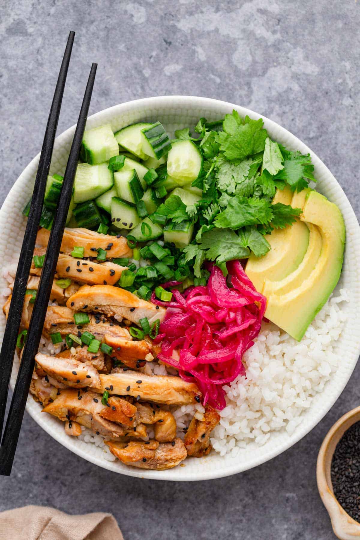 sesame soy chicken rice bowl with toppings.
