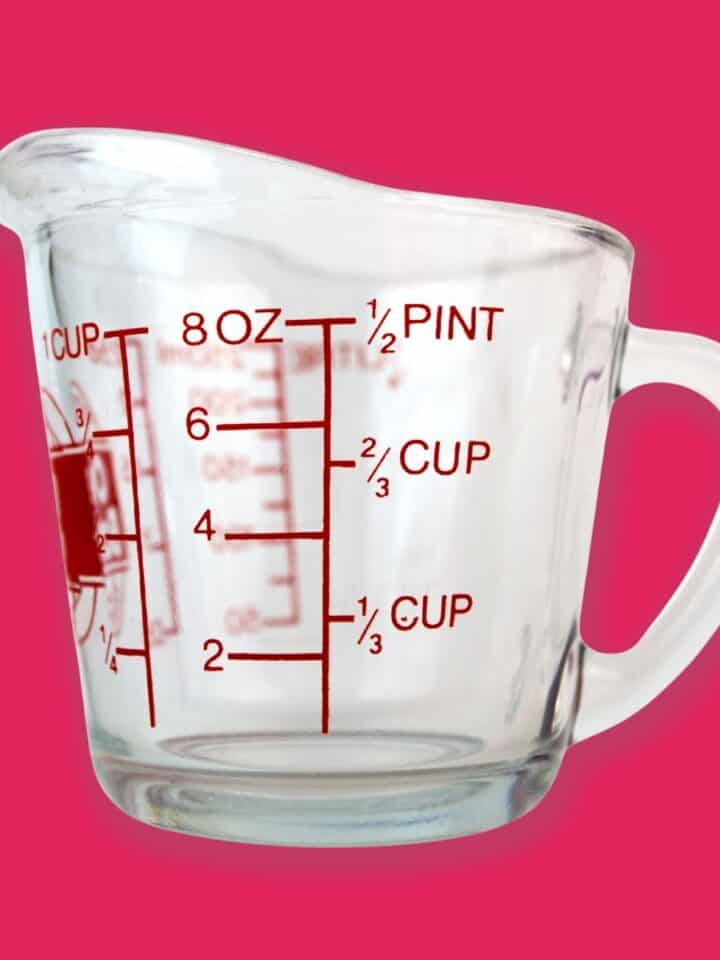 a measuring cup with pink background.