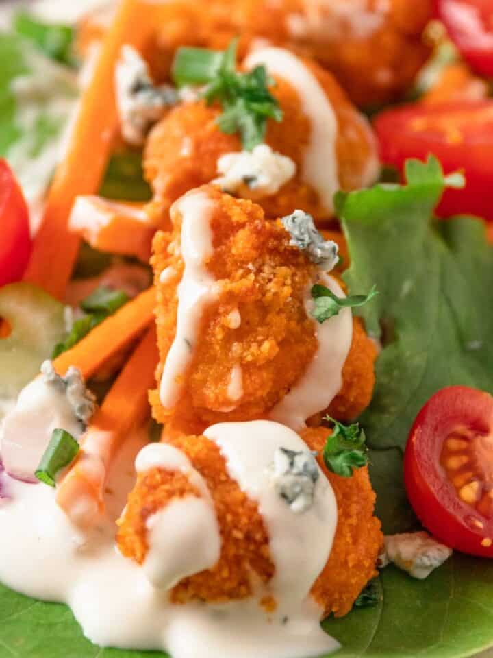 crispy chicken lettuce wraps in hot sauce.
