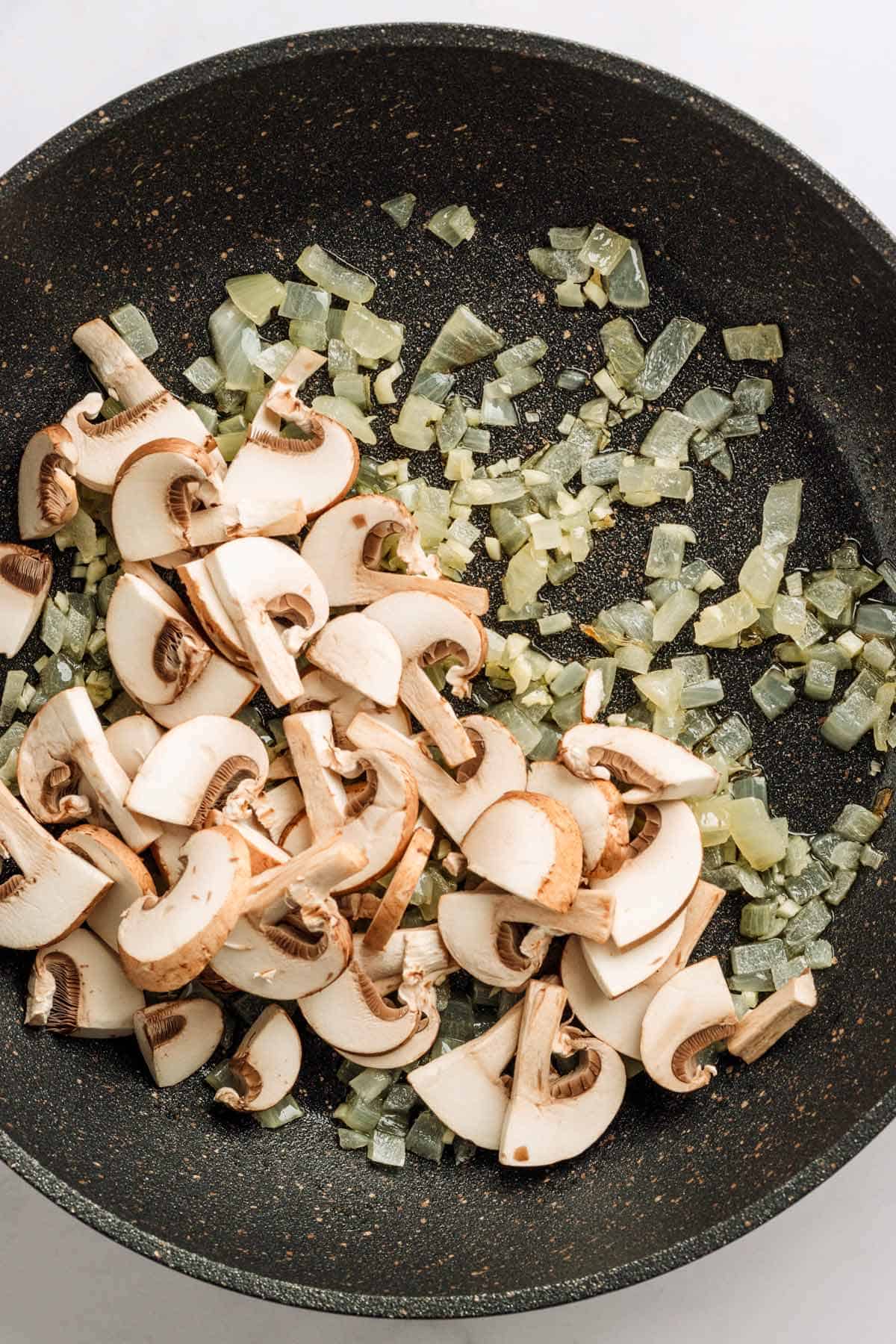 Mushrooms and onion in skillet for couscous.