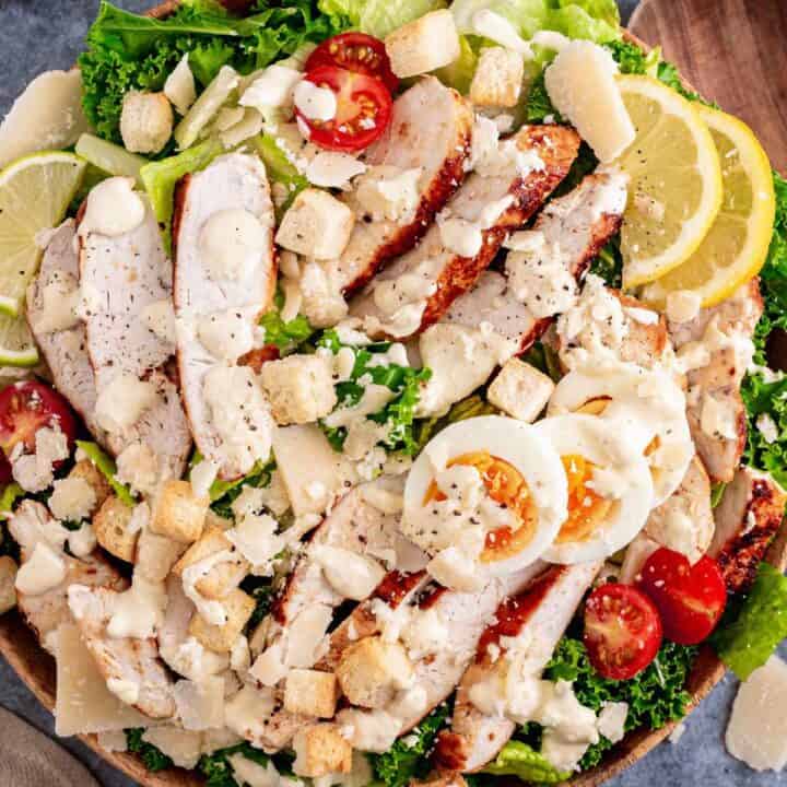kale caesar salad with chicken and lemon.