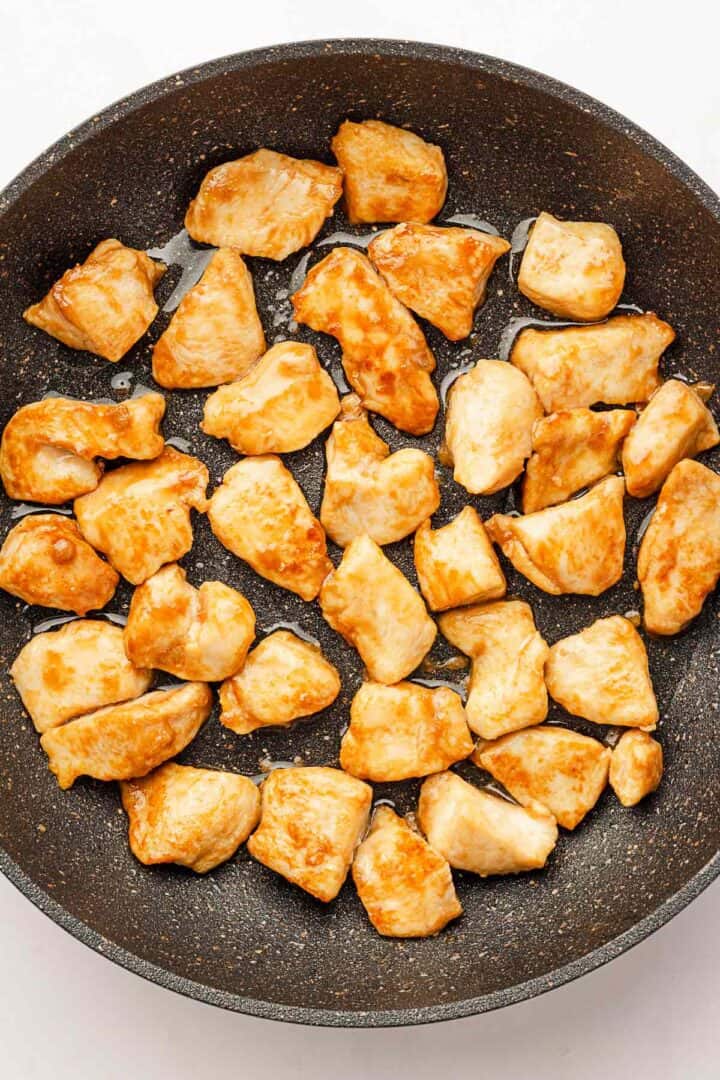 sauteed chicken pieces in skillet.